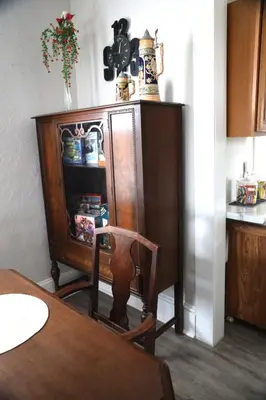 a kitchen with a wooden cabinet and a table with a chair at Werner Haus in Sandusky