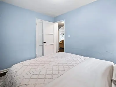 a white bed in a bedroom with blue walls at Modern 3Bed Home Near CLE With Private Backyard in Parma Heights