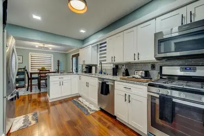 a kitchen with white cabinets and stainless steel appliances at South Euclid Home 10 Minutes to Cleveland Clinic in South Euclid