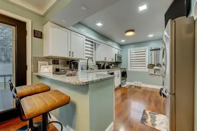 a kitchen with white cabinets and a refrigerator at South Euclid Home 10 Minutes to Cleveland Clinic in South Euclid