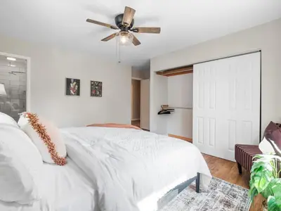 a bedroom with a white bed and a ceiling fan at Large Remodeled 4 Bed 3 Bath Secluded With Hot Tub in Akron