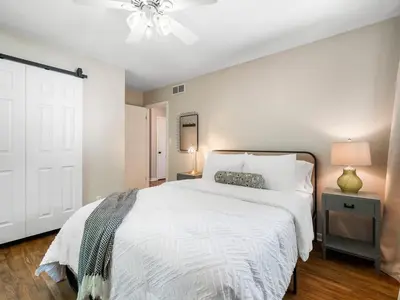 a bedroom with a white bed and a ceiling fan at Large Remodeled 4 Bed 3 Bath Secluded With Hot Tub in Akron
