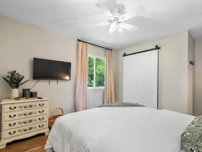 a bedroom with a white bed and a ceiling fan at Large Remodeled 4 Bed 3 Bath Secluded With Hot Tub in Akron