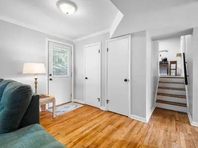a living room with a couch and a staircase at Large Remodeled 4 Bed 3 Bath Secluded With Hot Tub in Akron