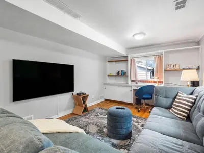 a living room with a couch and a flat screen tv at Large Remodeled 4 Bed 3 Bath Secluded With Hot Tub in Akron
