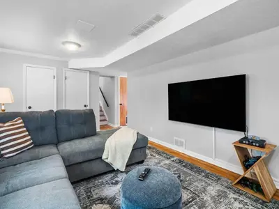 a living room with a couch and a flat screen tv at Large Remodeled 4 Bed 3 Bath Secluded With Hot Tub in Akron