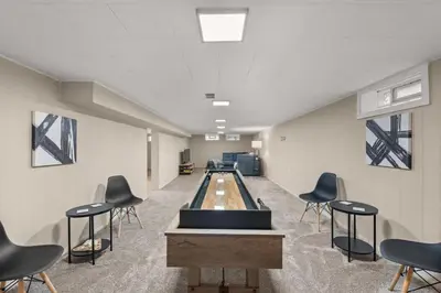 a room with a bowling alley with chairs in it at Hot Tub Game Room with Shuffleboard N64 Sleeps 8 in Parma Heights