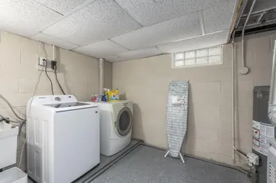 a laundry room with a washing machine and a washer at Hot Tub Game Room with Shuffleboard N64 Sleeps 8 in Parma Heights