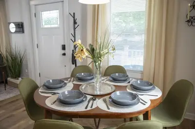a dining room table with chairs and a vase of flowers at Renovated and Professionally Designed 3Bed Home in Euclid