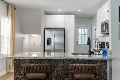 a kitchen with a large counter with two bar stools at Renovated and Professionally Designed 3Bed Home in Euclid