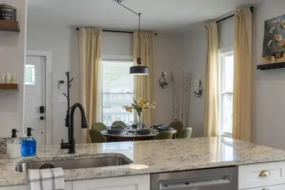 a kitchen with a sink and a dining room at Renovated and Professionally Designed 3Bed Home in Euclid