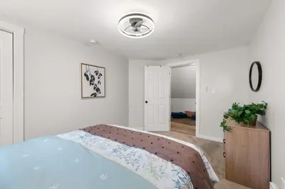 a white bedroom with a bed and a light at Renovated and Professionally Designed 3Bed Home in Euclid