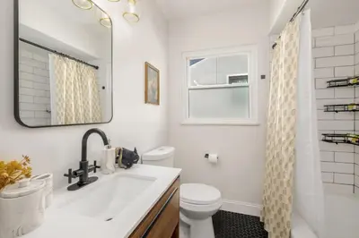 a bathroom with a sink and a toilet and a mirror at Newly Remodeled Home With a Game Room in Parma Heights