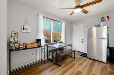 a kitchen with a white refrigerator and a table at Natures Retreat Renovated with Quiet Pond Views in Canal Fulton