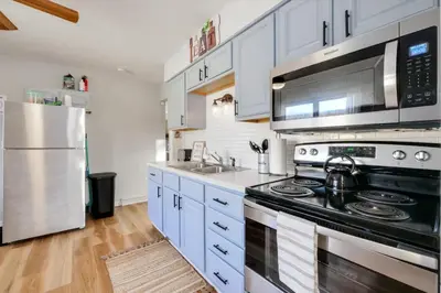 a kitchen with white cabinets and a black stove top oven at Natures Retreat Renovated with Quiet Pond Views in Canal Fulton
