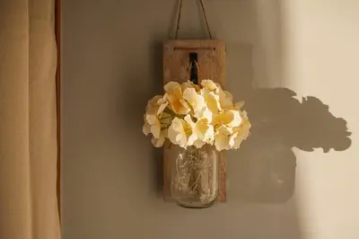 a vase with flowers in it hanging on a wall at Natures Retreat Renovated with Quiet Pond Views in Canal Fulton