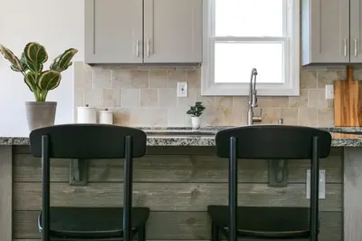 a kitchen with two black bar stools at a counter at Remodeled 4 Bedroom With a Game Room in Parma