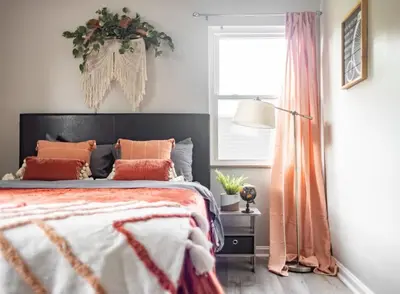 a bedroom with a bed with orange pillows and a window at Entire Secluded House Close To CLE Airport and BWU in Strongsville