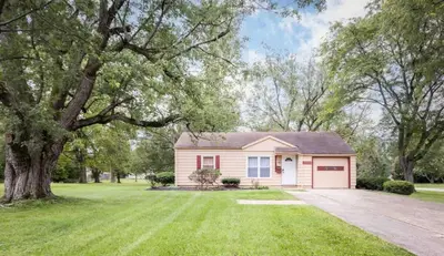 a small house with a tree and a driveway at Entire Secluded House Close To CLE Airport and BWU in Strongsville