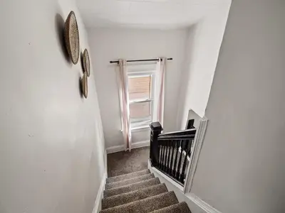 a hallway with a staircase with a window at Game Room 7 Min To Downtown CLE in Cleveland