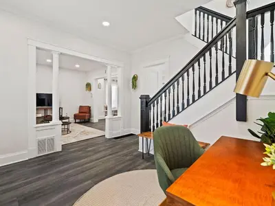 a living room with a dining room table and stairs at Game Room 7 Min To Downtown CLE in Cleveland