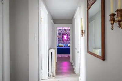 a hallway with a room with a bed and a mirror at Large Renovated 4 Bedroom Home 9 min to Downtown CLE in Cleveland