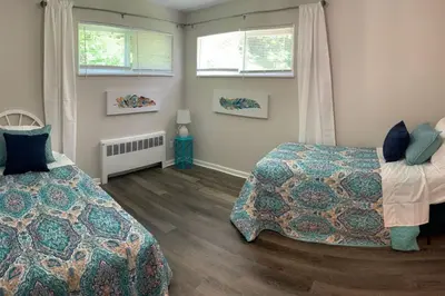 a bedroom with two beds and two windows at Filled with warmth and comfort Home away from home in Cincinnati