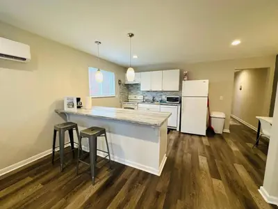 a large kitchen with a counter and stools in it at Cozy Retreat Apartment in Cincinnati