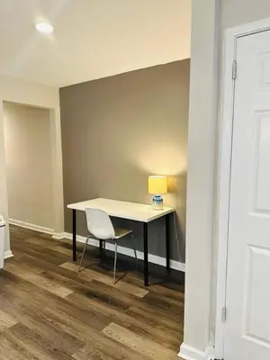a desk with a lamp and a chair in a room at Cozy Retreat Apartment in Cincinnati