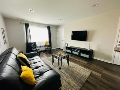 a living room with a leather couch and a tv at Reading-Stylish Apartment for Contemporary Comfort in Cincinnati