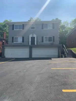 a large house with a garage in a parking lot at Reading-Stylish Apartment for Contemporary Comfort in Cincinnati