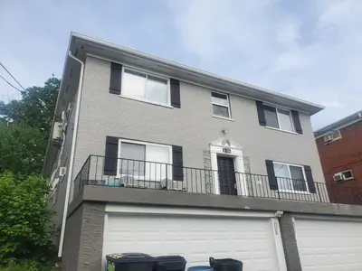 a large house with a garage and a balcony at Reading-Stylish Apartment for Contemporary Comfort in Cincinnati
