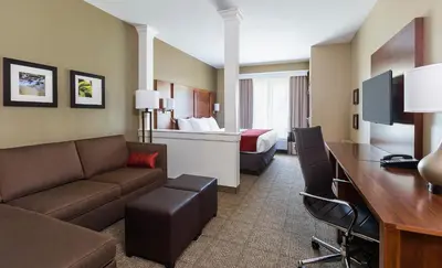 a living room with a couch and a desk in a hotel room at Comfort Suites Hartville-North Canton in Uniontown
