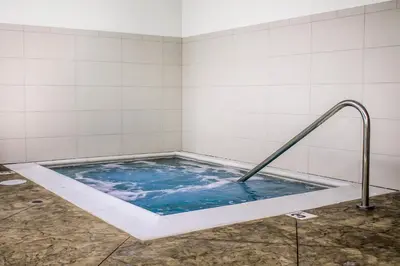 a jacuzzi tub with a metal rail in a bathroom at Comfort Suites Hartville-North Canton in Uniontown