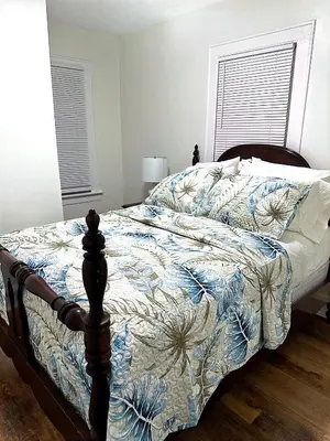 a bedroom with a bed with a blue and white comforter at LOVELY FURNISHED HOUSE FOR rent in Akron