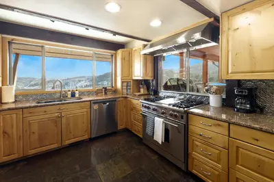a kitchen with wooden cabinets and a stove top oven at Cozy Rustic Escape Near Park City Adventures in Defiance