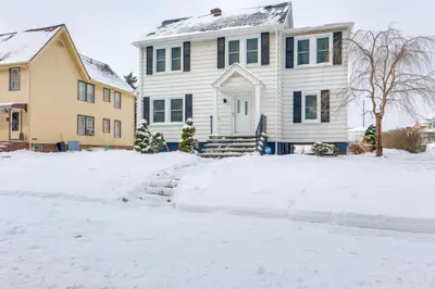 a house with a snow covered driveway in front of it at 11 Mi to Dtwn Cleveland Family Home with Yard in Garfield Heights