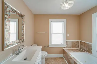 a bathroom with a tub and a toilet and a sink at 11 Mi to Dtwn Cleveland Family Home with Yard in Garfield Heights