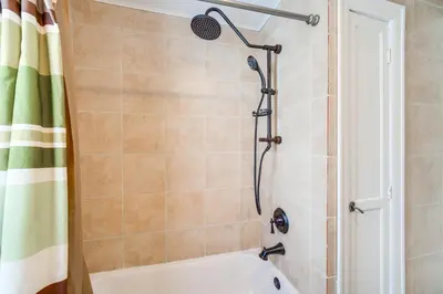 a bathroom with a shower with a tub at 11 Mi to Dtwn Cleveland Family Home with Yard in Garfield Heights