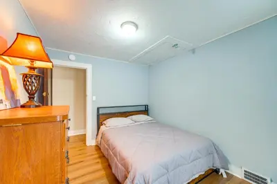 a bedroom with a bed and a desk with a lamp at 11 Mi to Dtwn Cleveland Family Home with Yard in Garfield Heights