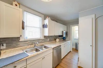 a kitchen with white cabinets and a sink at 11 Mi to Dtwn Cleveland Family Home with Yard in Garfield Heights