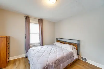 a bedroom with a large bed and a window at 11 Mi to Dtwn Cleveland Family Home with Yard in Garfield Heights