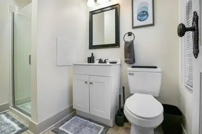 a bathroom with a toilet and a sink and a mirror at Victorian Cozy Retreat Steps to Cleveland Clinic in Cleveland