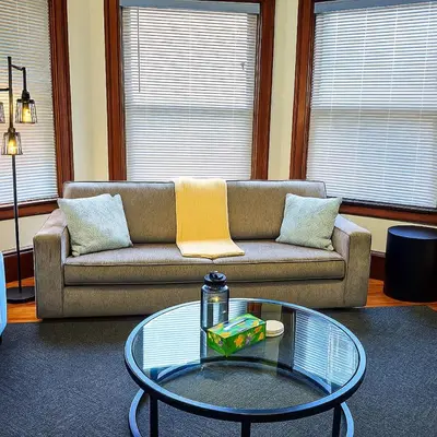 a living room with a couch and a glass table at Victorian Cozy Retreat Steps to Cleveland Clinic in Cleveland