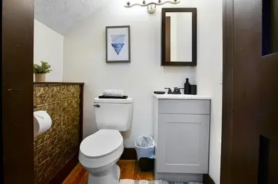 a bathroom with a white toilet and a sink at Victorian Cozy Retreat Steps to Cleveland Clinic in Cleveland