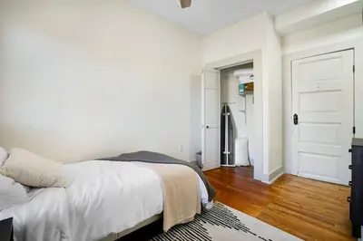 a white bedroom with a bed and a hallway at Victorian Cozy Retreat Steps to Cleveland Clinic in Cleveland