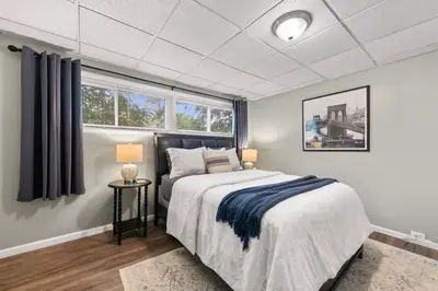 a bedroom with a bed and two windows at Walkable Neighborhood of Kamm's Corners in Cleveland