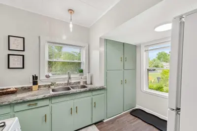 a kitchen with green cabinets and a window at Walkable Neighborhood of Kamm's Corners in Cleveland