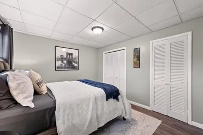 a bedroom with a bed and white walls at Walkable Neighborhood of Kamm's Corners in Cleveland