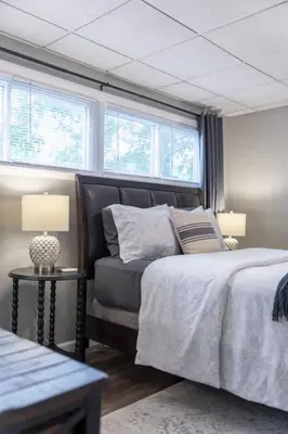 a bedroom with a bed and a couch and windows at Walkable Neighborhood of Kamm's Corners in Cleveland